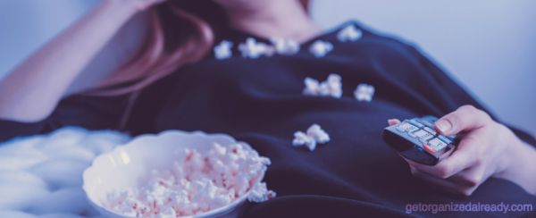 girl holding remote with popcorn